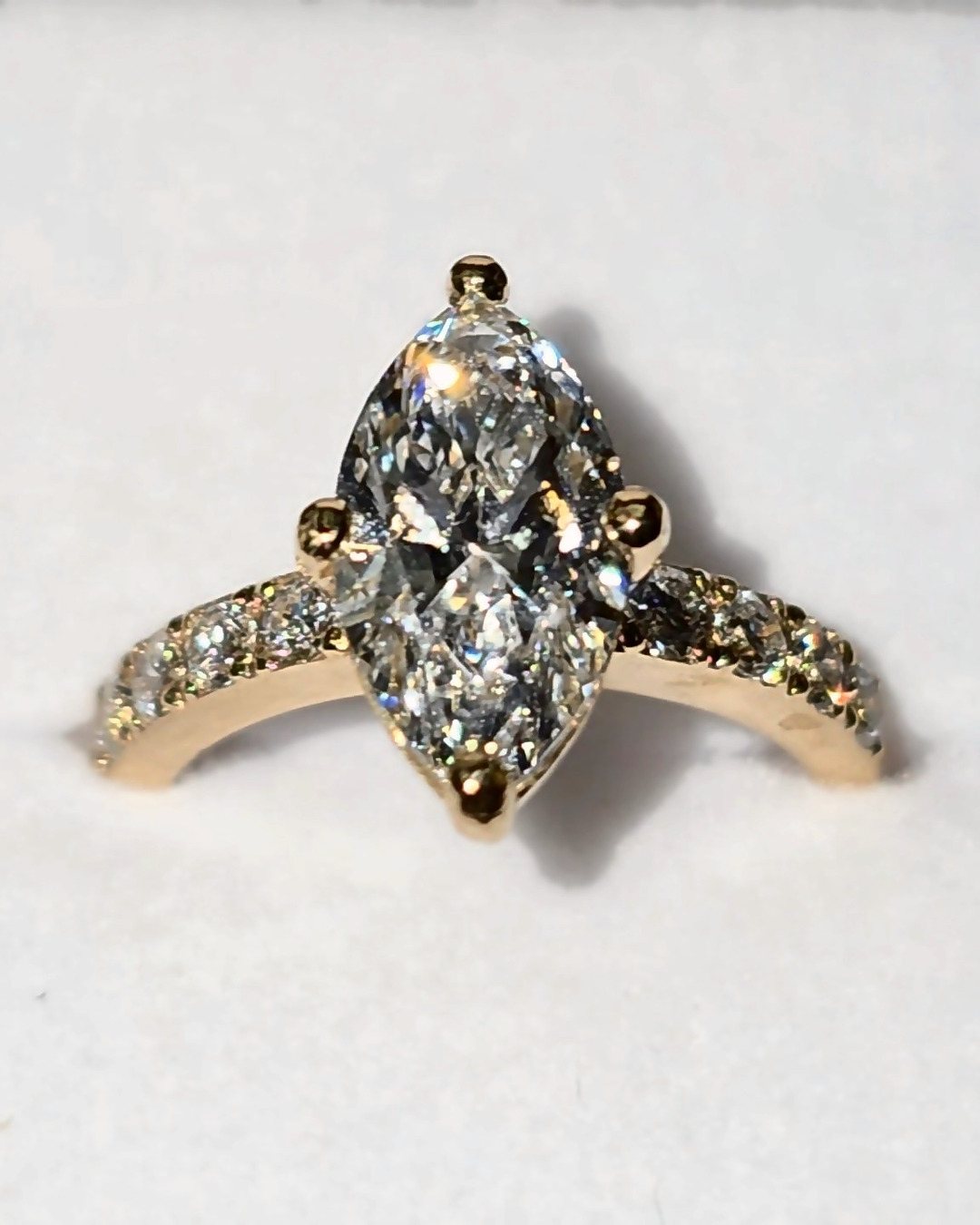 Marquise cut diamond solitaire with pavé band in yellow gold